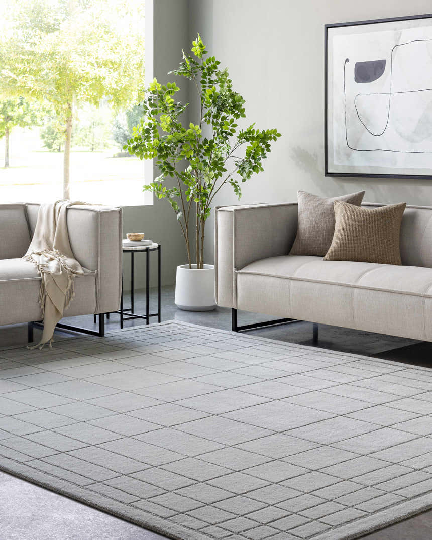 Contemporary living room with gray sofas and a Sedna Gray Wool Area Rug featuring a geometric grid pattern. Roomscene-Rectangle