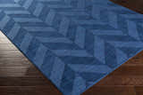 Close-up of the navy Searsmont Area Rug on dark wood flooring. Geometric chevron pattern. Clearance rug. Corner