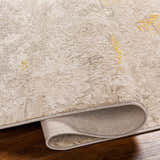 Close-up of the Yuji Area Rug in beachhouse. Shows the rug's neutral tones, subtle pattern, and rolled edge. Fold