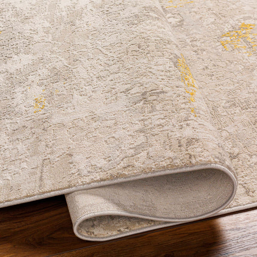 Close-up of the Yuji Area Rug in beachhouse. Shows the rug's neutral tones, subtle pattern, and rolled edge. Fold