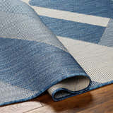 Close-up of the Adwen Blue Area Rug showing its geometric pattern, blue and light gray colors, and woven texture. Fold
