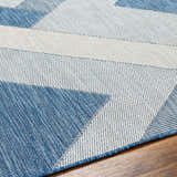 Close-up of the Adwen Blue Area Rug, showcasing its geometric pattern and woven texture in slate blue and white. Texture