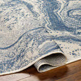 Close-up of the Basma Blue Marble Area Rug, showcasing its woven texture and blue and light gray contemporary pattern. Fold