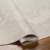 Close-up of the Estee Cream Snake-Patterned Area Rug showing beige, bone, and gray tones and subtle textured design. Fold
