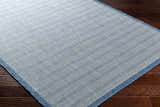 Close-up of the Genet Blue Area Rug showing its denim and arctic stone chevron pattern and woven texture. Corner