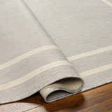 Close-up of the Ilori Light Gray Area Rug showing its woven texture and light gray and cream striped pattern. Fold