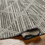 Close-up of the Ivory Black & White Area Rug, showcasing its contemporary woven texture and geometric pattern. Fold