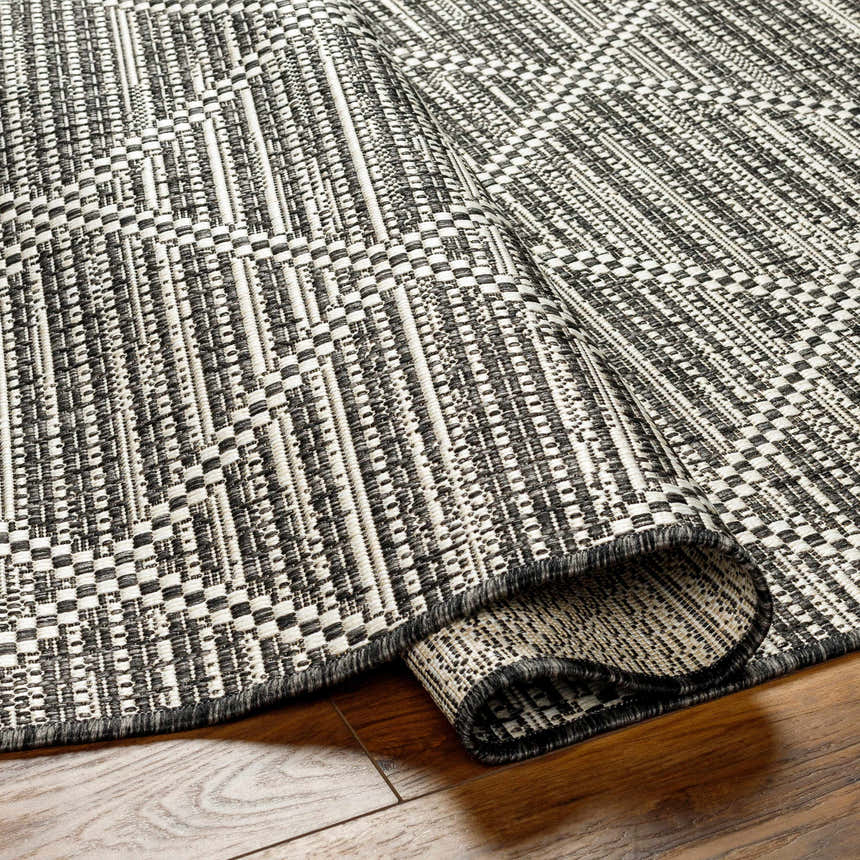 Close-up of the Ivory Black & White Area Rug, showcasing its contemporary woven texture and geometric pattern. Fold