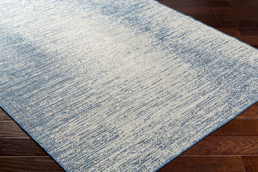 Close-up of Medi Silver Blue Area Rug showing its contemporary beige and blue abstract pattern and woven texture. Corner