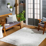 Cozy patio scene with wood furniture and a cream Southwestern style Jove Cream Outdoor Rug. Roomscene-Rectangle