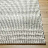 Close-up of the hand woven Lenci Bone Area Rug. Beige and bone wool and cotton rug with a braided texture. Front