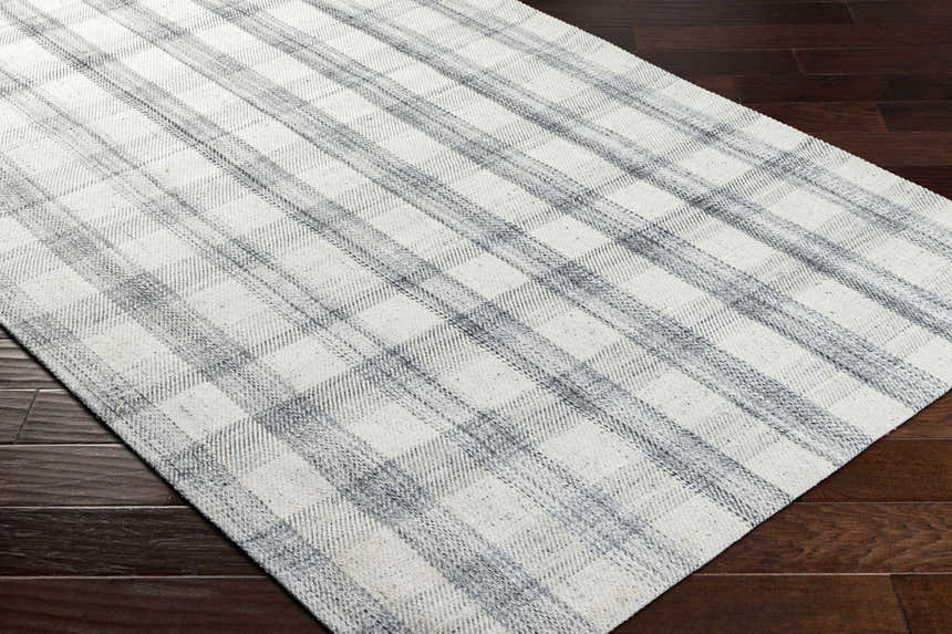 Close-up of the Leeba Gray Plaid Area Rug showing its woven texture and farmhouse style gray and white plaid pattern. Corner