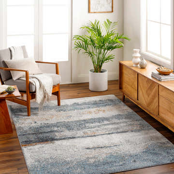 Living room scene with gray chair and Adam Gray Blue Abstract Area Rug on a wood floor. Roomscene-Rectangle