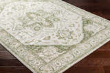 Close-up of Gauri Green Medallion Area Rug on dark wood floor. Farmhouse style rug with traditional medallion pattern. Corner