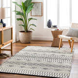 Living room scene with a geometric Carly Area Rug in dark gray and off-white on hardwood floors. Contemporary style. Roomscene-Rectangle