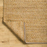 Close-up of the Doris Beige Area Rug showing its woven jute and cotton texture and neutral camel color on wood floors. Fold