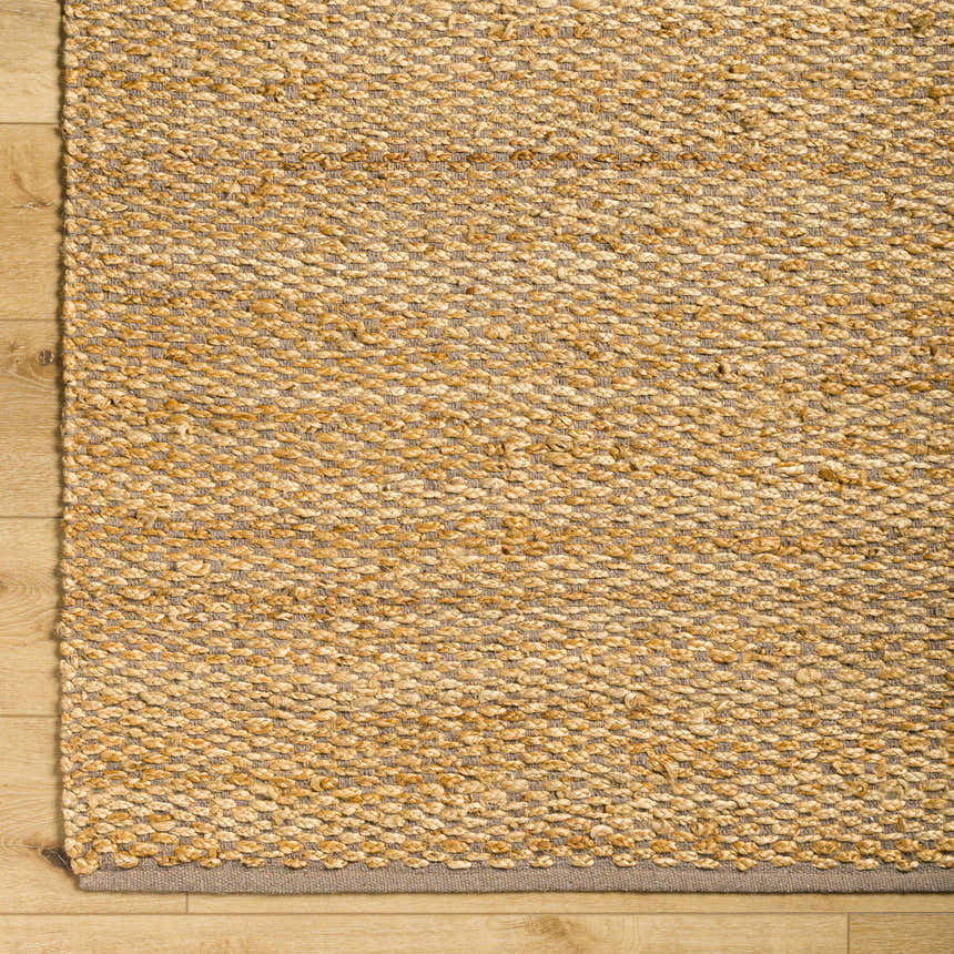 Close-up of Doris Beige Area Rug showing hand-woven jute and cotton texture with a neutral gray border on wood floor. Swatch