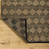 Close-up of the hand-woven Irina Area Rug. Medium brown and nutmeg jute and cotton blend with a traditional geometric pattern. Fold