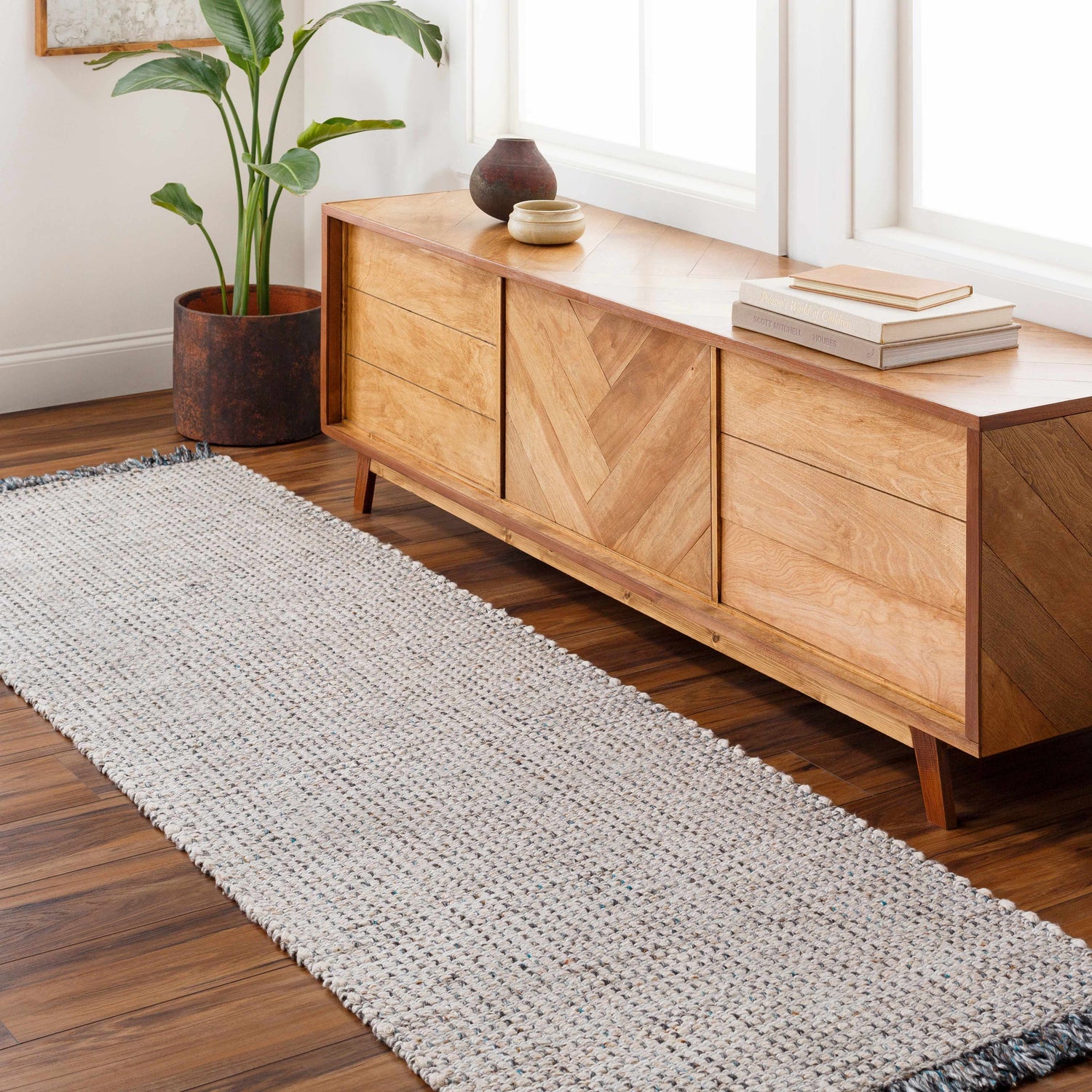 Entryway with Beige Teal Aron Area Rug runner, wood console table, plant, and wood floors. Roomscene-Runner