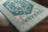 Close-up of the hand-knotted Stepps Area Rug. Aqua, beige, and sage colors in a traditional, bohemian pattern. 100% wool. Corner
