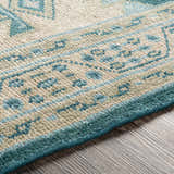 Close up of the hand knotted Stepps Area Rug featuring aqua, beige and sage colors. Texture