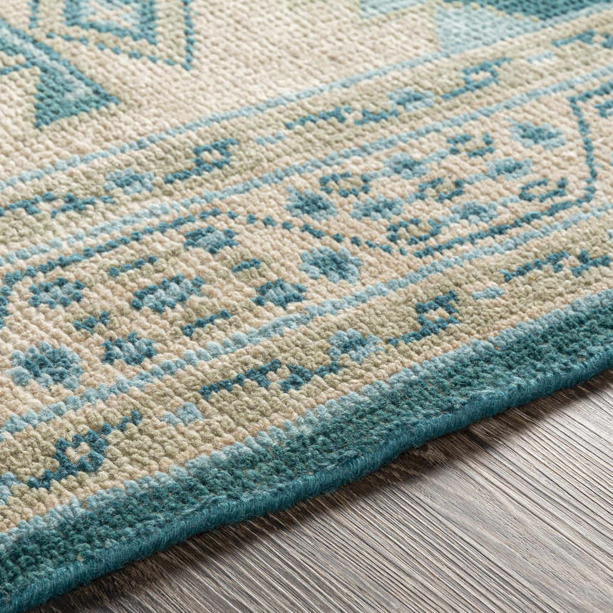 Close up of the hand knotted Stepps Area Rug featuring aqua, beige and sage colors. Texture