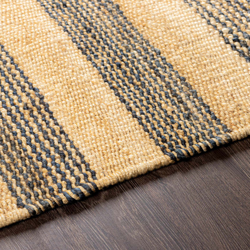 Close-up of Stapleford Striped Jute Carpet showing cream and navy stripes, and hand-woven texture on dark wood floor. Texture