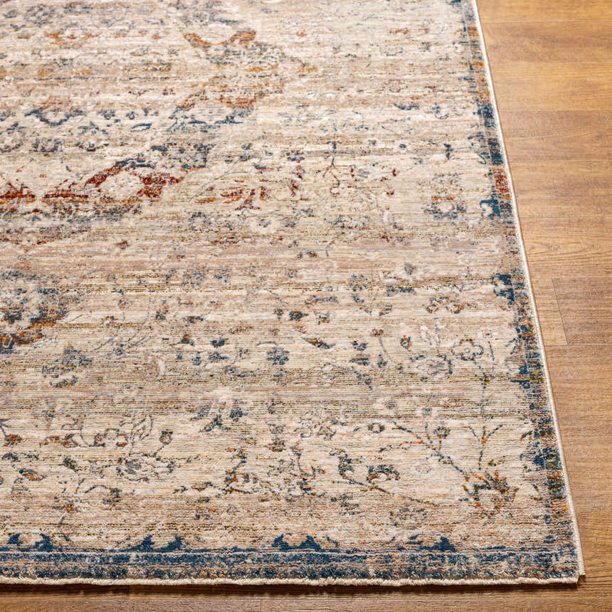 Close-up of the Stratmoor Area Rug. Beige, blue, and burnt orange traditional pattern on a polyester rug with a subtle texture. Front