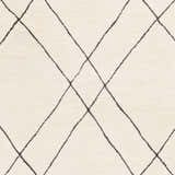Close-up of the Strathalbyn Area Rug. Cream wool rug with a simple black diamond pattern. Hand-tufted texture. Swatch
