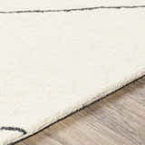 Close up of the Strathalbyn Area Rug. Cream wool rug with black geometric pattern and hand tufted texture. Texture