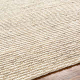 Close-up of the hand woven Dewei Area Rug. Beige and tan wool rug with a textured, striped pattern on hardwood floor. Texture