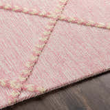 Close-up of the Stoutland rug. Cream and mauve wool rug with a striped pattern and raised geometric design. Texture