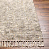 Close-up of the Amiel Beige rug showing its hand woven texture, neutral colors, and fringe detail on a wood floor. Front