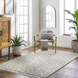 Light-filled room with Amiel Beige Hand Woven Area Rug, wood cabinet, chair with pillow, and plants for a contemporary style. Roomscene-Rectangle