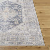 Close-up of the Keola Washable Area Rug showing its farmhouse style, traditional pattern, and soft gray and beige colors. Front