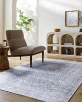 Neutral living room with a gray chair and the blue Odele Washable Area Rug. Roomscene-Rectangle