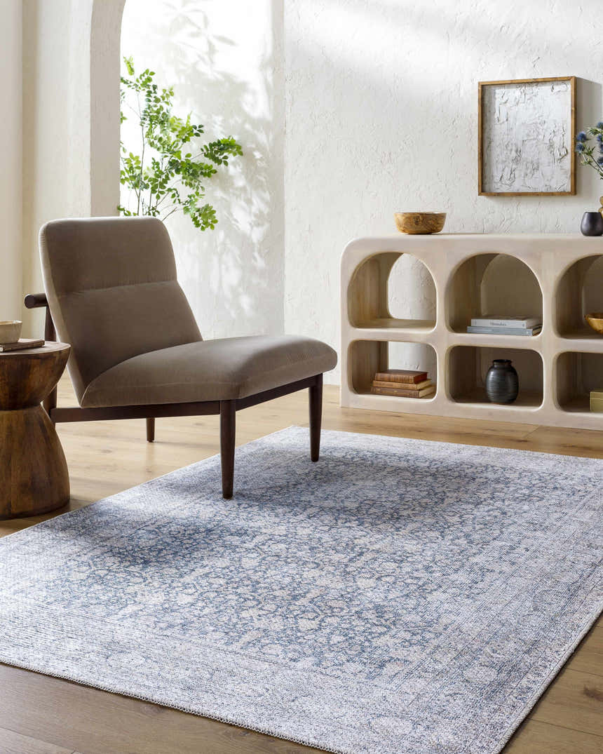Neutral living room with a gray chair and the blue Odele Washable Area Rug. Roomscene-Rectangle
