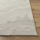 Close up of the Siani Cream Wool Area Rug showing its hand-tufted texture and ash and silver gray wavy pattern. Front