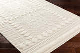 Close-up of the Elese Area Rug in beige. Contemporary style with geometric patterns and plush texture. Corner