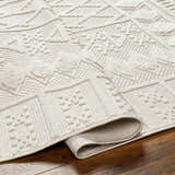 Close-up of the Elese Area Rug in beige. Features a contemporary geometric design and textured, raised details. Fold
