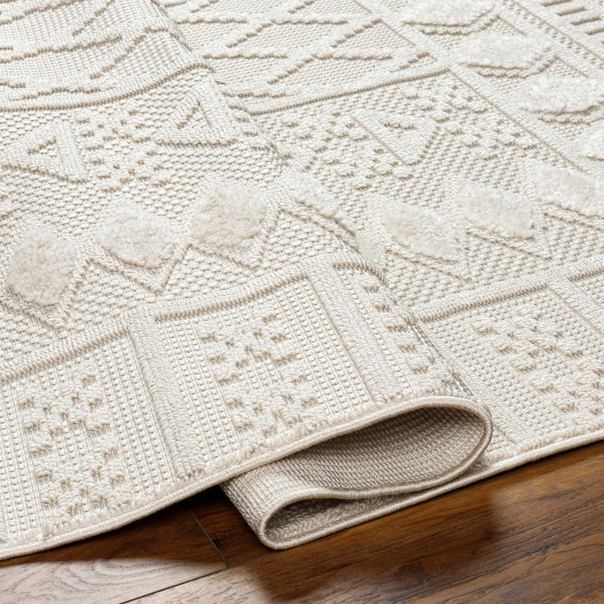 Close-up of the Elese Area Rug in beige. Features a contemporary geometric design and textured, raised details. Fold
