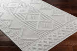 Close-up of the Arctic Stone Gabin Area Rug showing geometric patterns and textured details on a dark wood floor. Corner