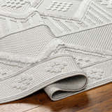 Close-up of the Arctic Stone Gabin Area Rug showing the contemporary geometric pattern and textured weave. Fold