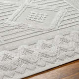 Close-up of the Gabin Area Rug showing the arctic stone color, geometric pattern, and textured, machine-woven construction. Texture
