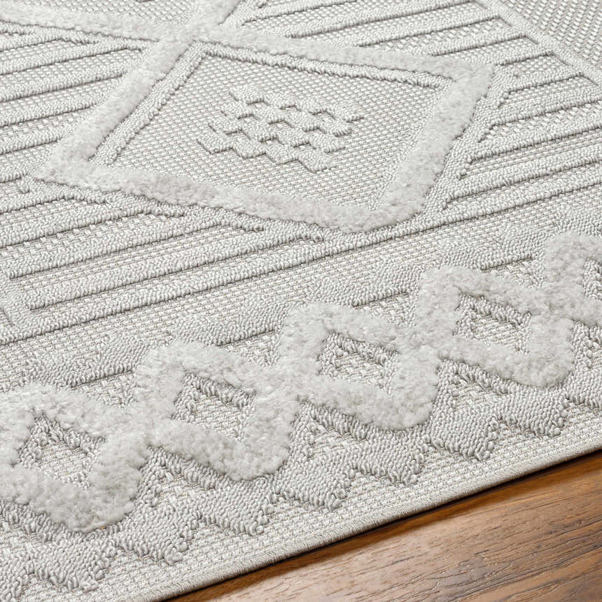 Close-up of the Gabin Area Rug showing the arctic stone color, geometric pattern, and textured, machine-woven construction. Texture