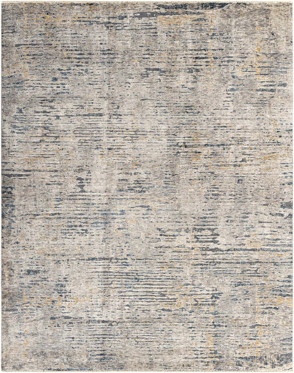 Close-up of the Sywell Luxe Fringe Rug. Beige rug with blue, charcoal, and tan abstract pattern and subtle fringe. Design-Rectangle-710103