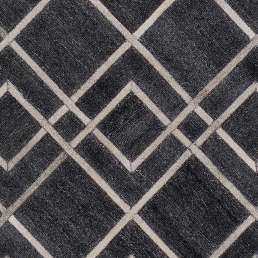 Close-up of the Taclobo Area Rug. Black rug with light gray geometric diamond pattern. Hand-crafted viscose rug. Swatch