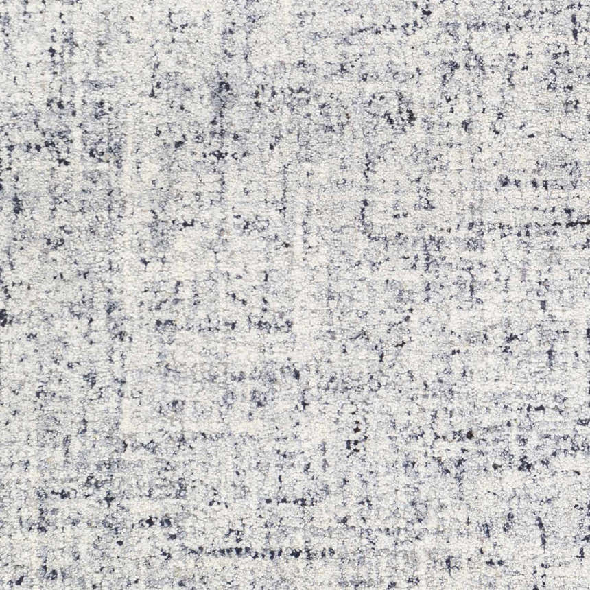 Close-up of the hand-tufted Tanana Area Rug. Cream wool rug with a contemporary black and gray abstract pattern. Swatch