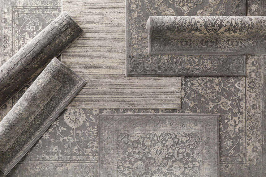 Close-up of gray Benavides Updated Traditional Tibetan Rugs in various shapes and sizes showing detailed floral patterns. Styleshot