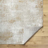 Close-up of the Tapko Tan Area Rug showing its abstract tan and cream pattern and machine-woven texture. Fold